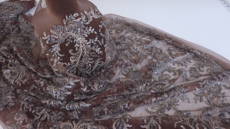 Dantelă maro ciocolată cu accesorii metalice pe manechin maro