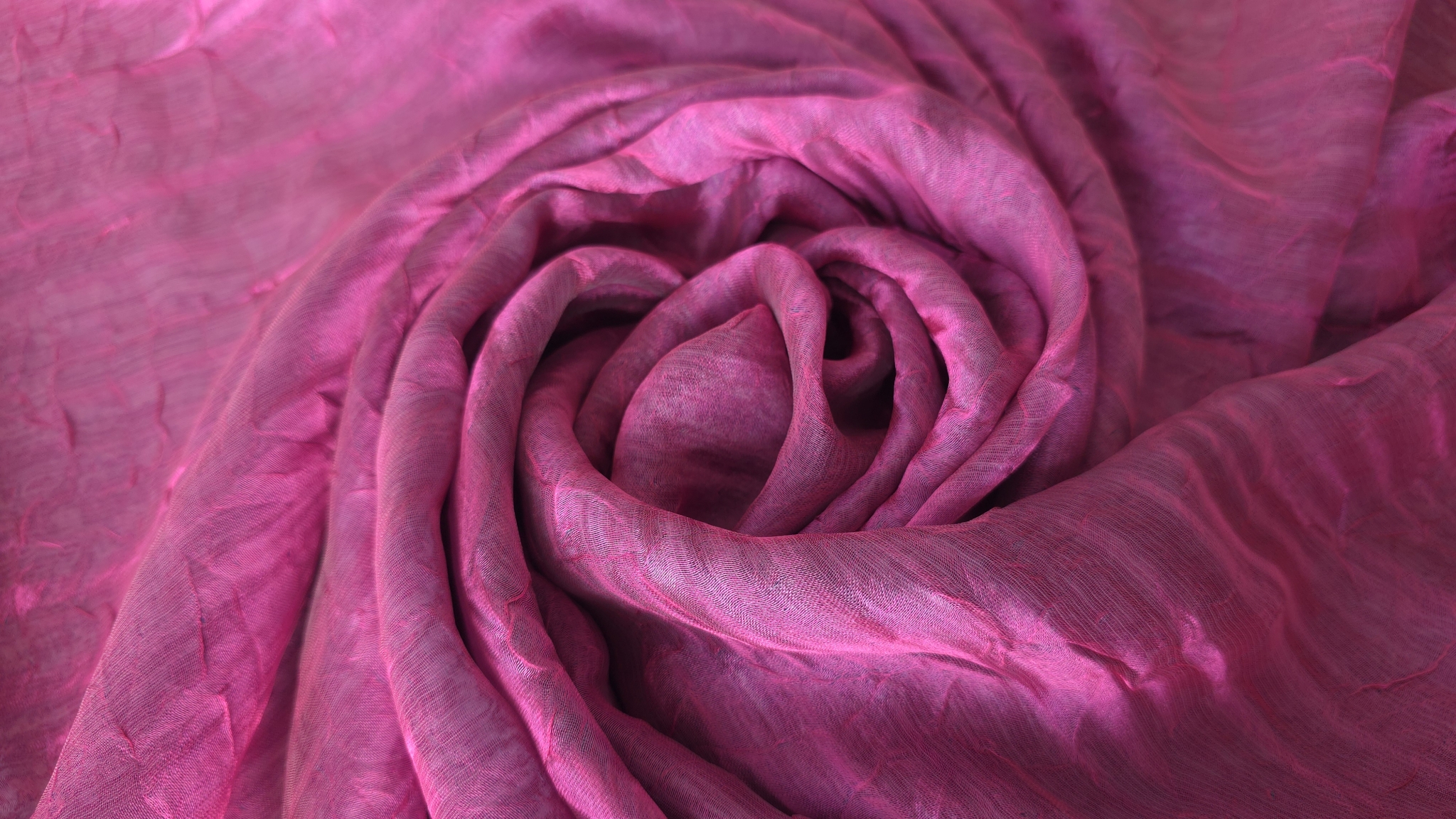 Țesătură fină fuxia răsucită în spirală, cu pliuri concentrice și reflexii lucioase